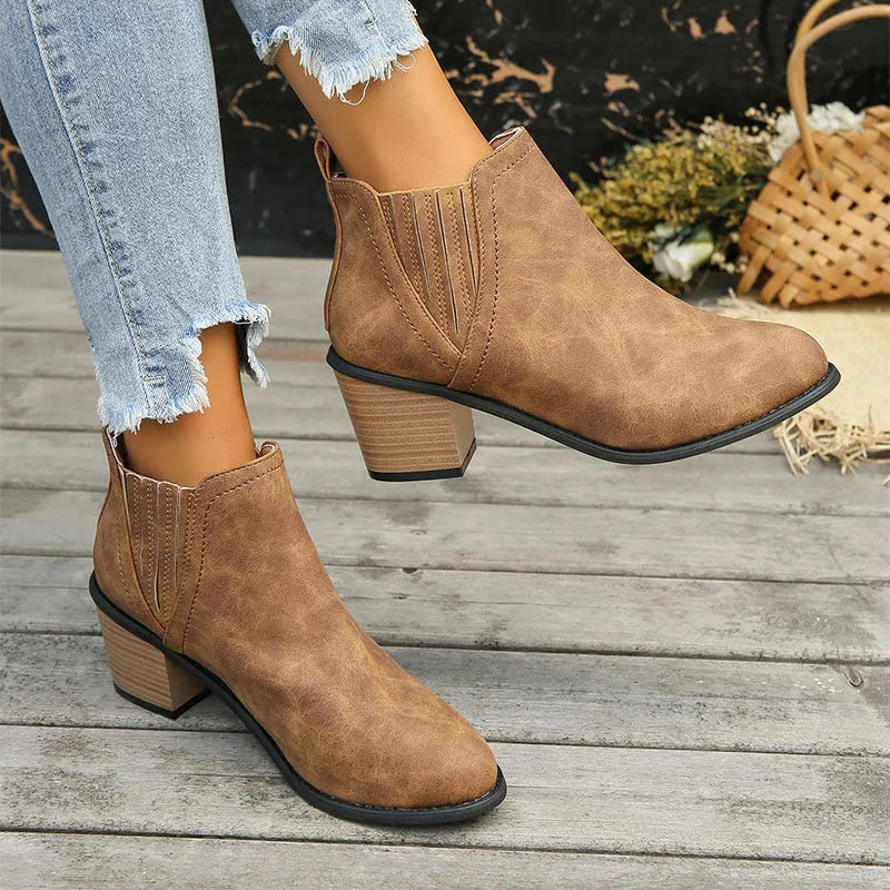 Black women's ankle boots with a pointed toe, thick square low heel, and slip-on design on a white background.