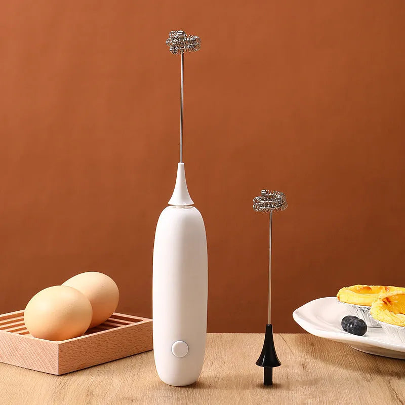 Black and white electric hand-held milk frother for coffee drinks