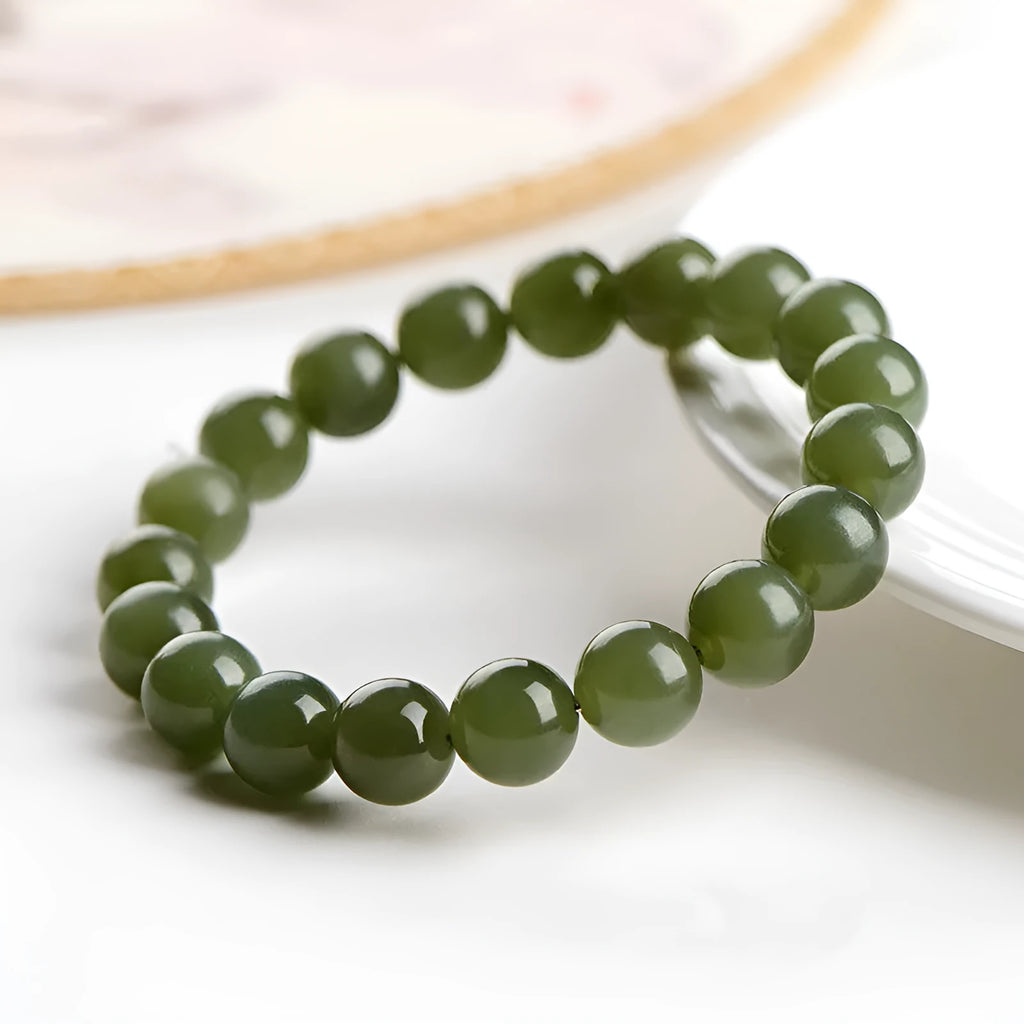 A polished Hetian jade bead bracelet in a light ice-clear colour, showing smooth round beads on a string.