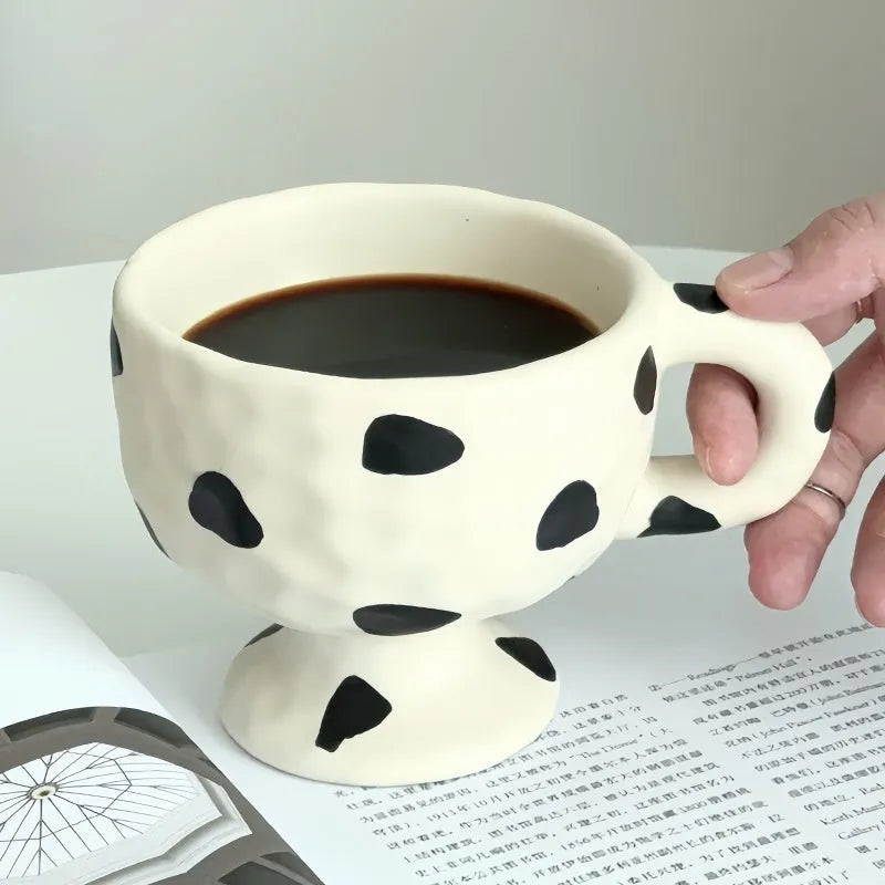 Hand-pinched irregular ceramic mug in a solid colour, showing unique handmade shape.