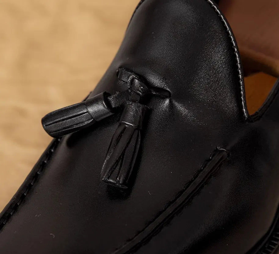 Men's brown leather loafers with fringed detail and slip-on design on rubber sole