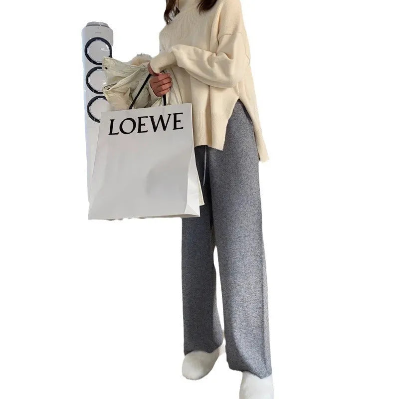 Women's high waist wide-leg knit trousers in cream white colour, laid flat to show straight-leg cut.