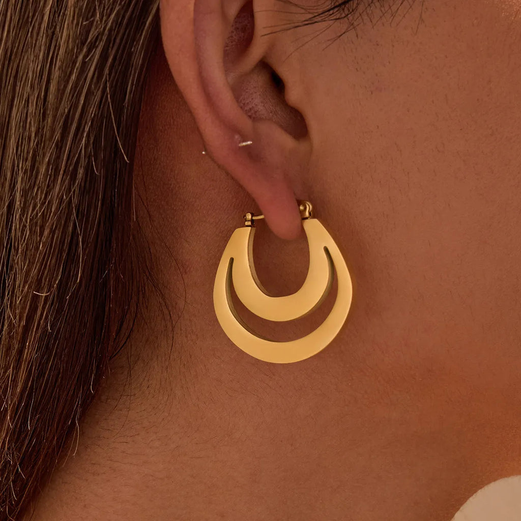 Geometric gold plated hoop earrings with round ring design on stainless steel background