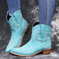 Women's blue embroidered cowboy boots with a low wedge heel and pointed toe.