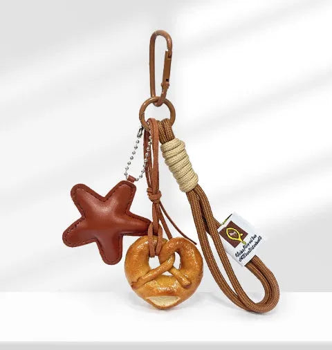 Handmade brown polymer clay soda bread charm on a brown strap, showing cartoon bread design details.