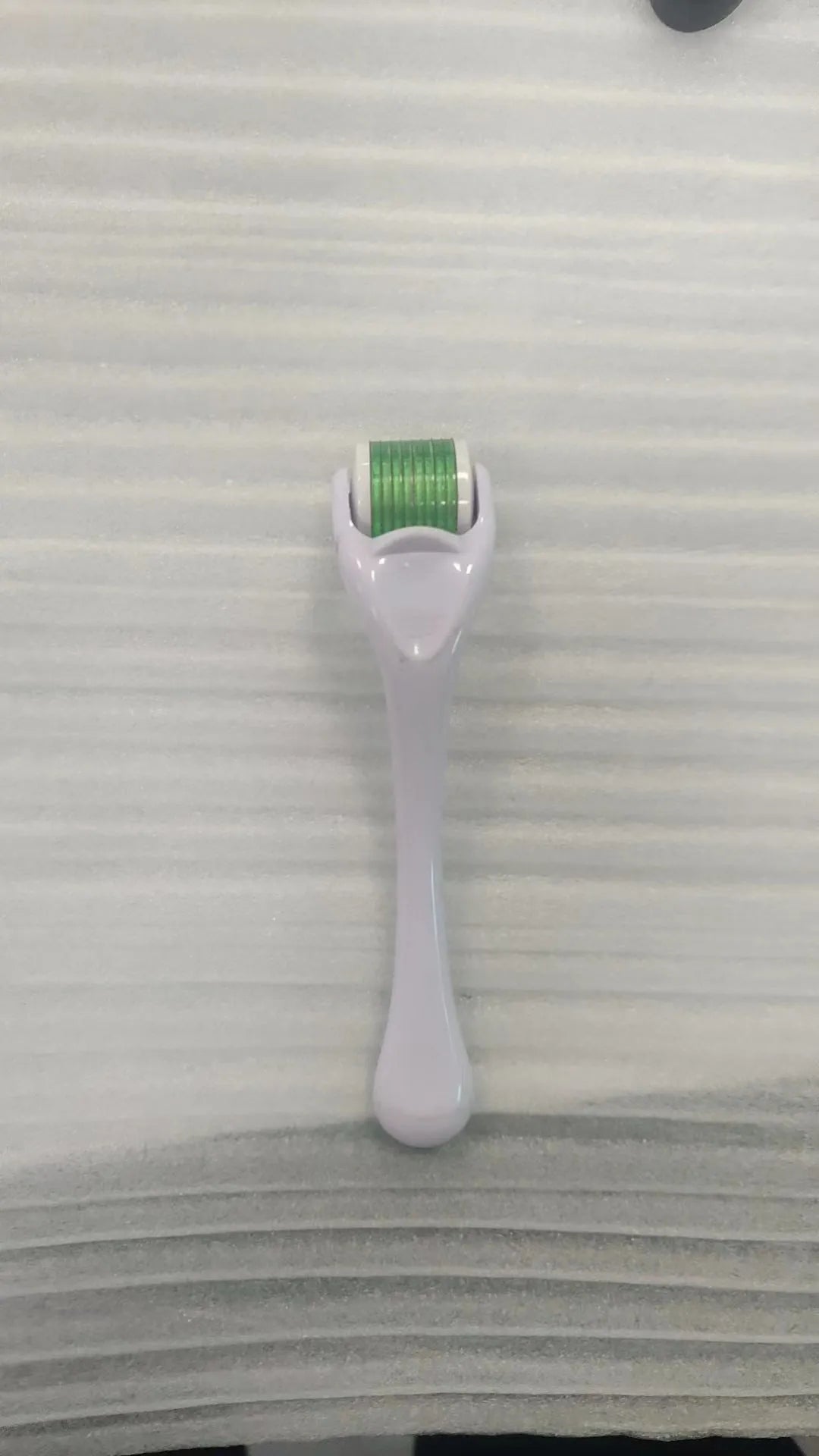 540 needle micro roller dermaroller with black handle and purple wheel, showing needle depth settings.