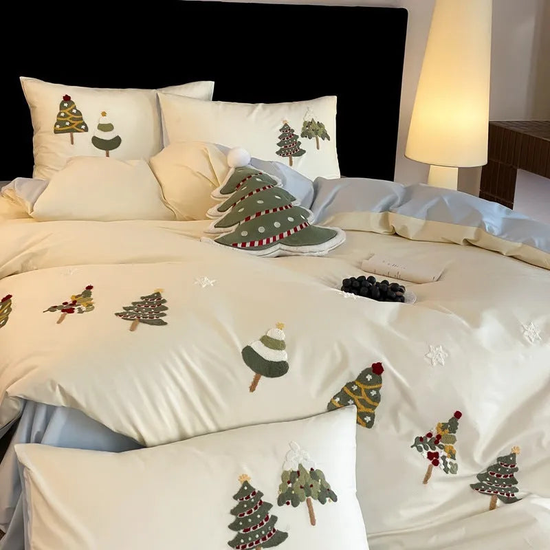 Four-piece cotton bedding set with Christmas tree towel embroidery pattern showing duvet cover, bed sheet, and pillowcases