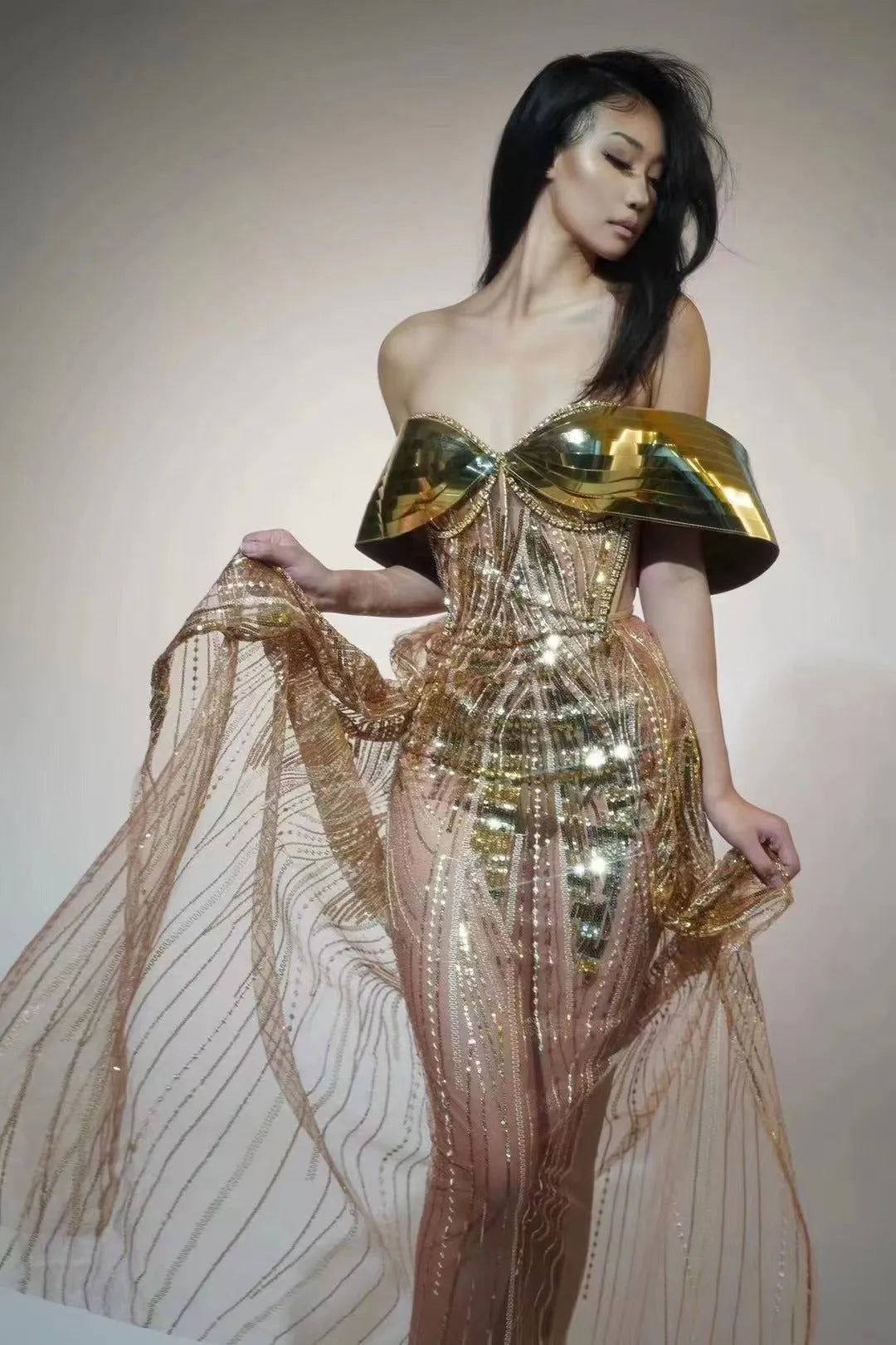 Gold sequined strapless long evening dress with a high split on the skirt, shown on a model.