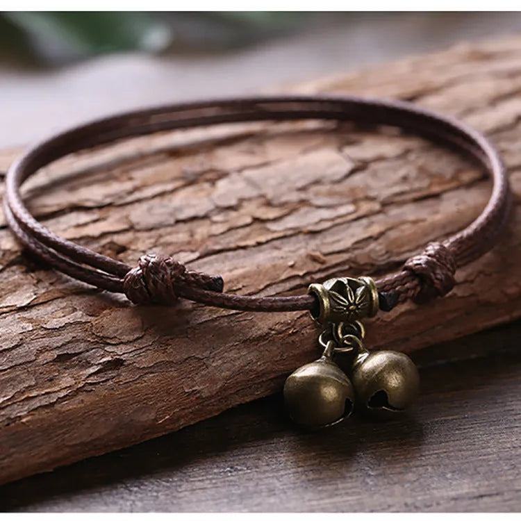 Small dog wearing adjustable nylon rope collar with brass bell in black, red or coffee colour