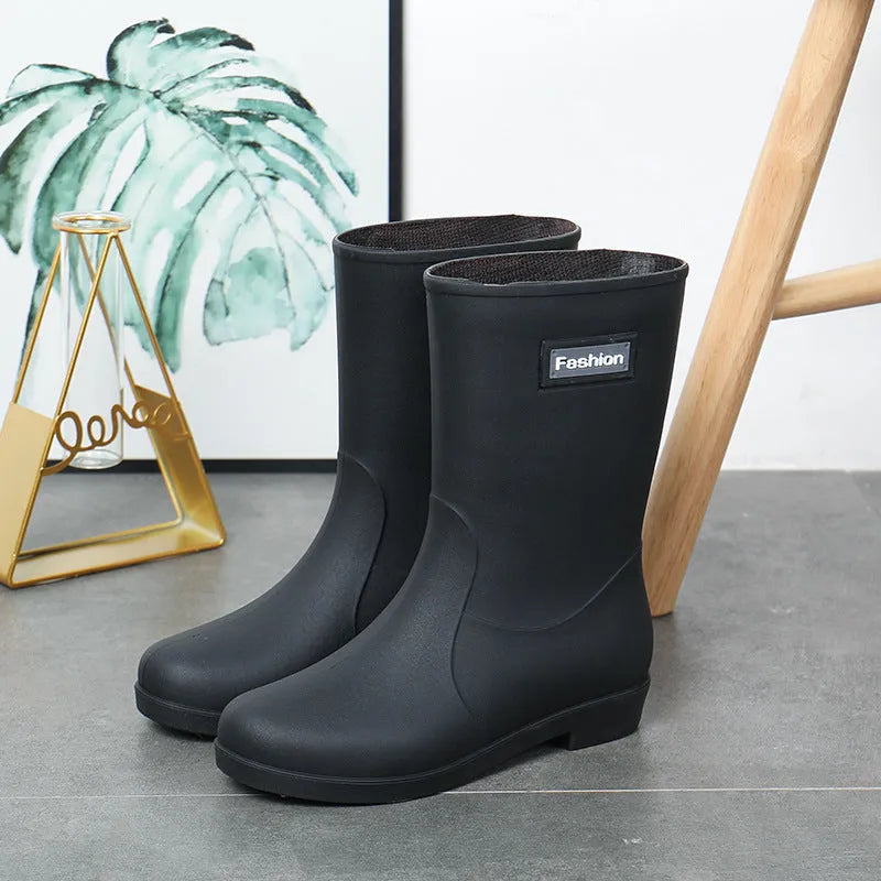 Women's black PVC rain boots with mid-calf height and low heel