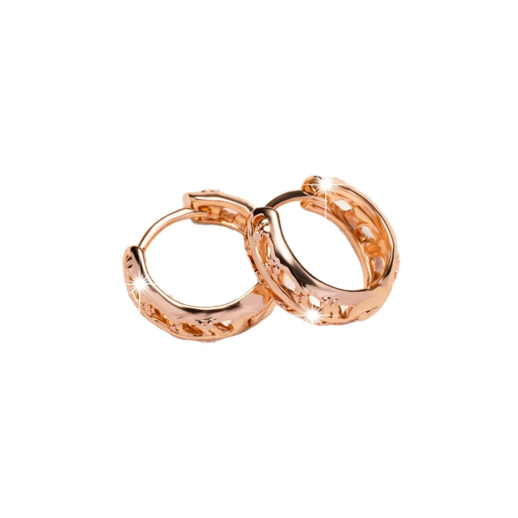 Small copper earrings with a hollowed-out heart-shaped leaf design in rose gold finish.