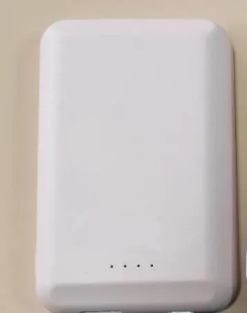 A black magnetic wireless power bank with a 5000mAh capacity, shown next to a smartphone.