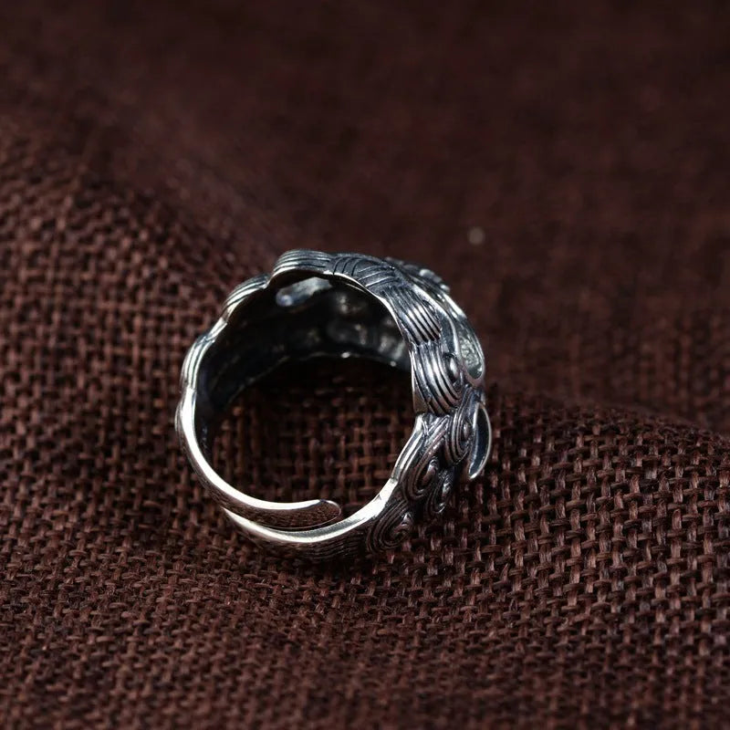 Silver open ring with detailed Jibeast zodiac animal pattern, shown on a hand.