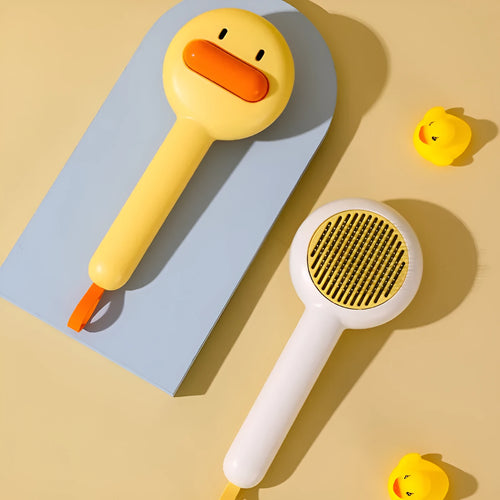 Yellow and white pet grooming comb with duck design and needle teeth for cats and dogs.