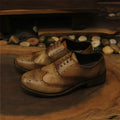 Light brown men's vintage distressed leather shoes with engraved detailing and lace-up closure