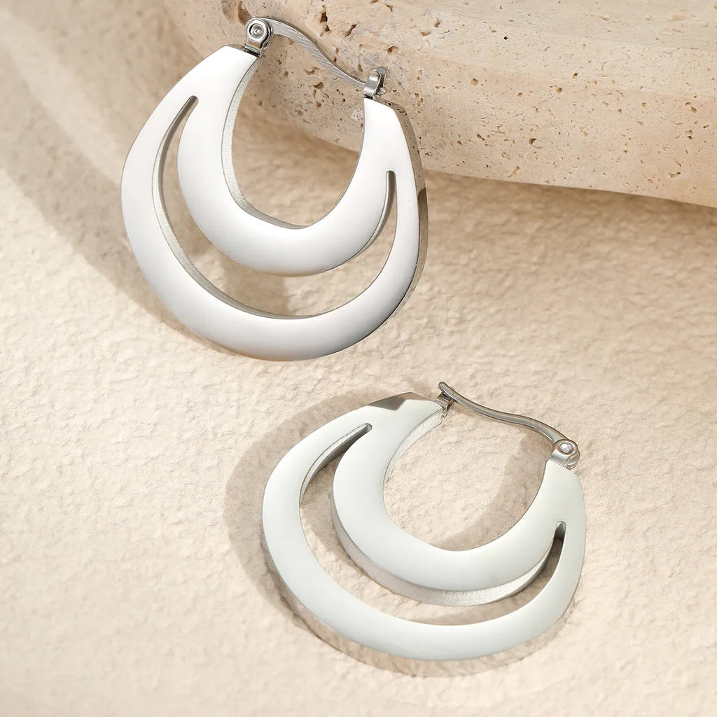 Geometric gold plated hoop earrings with round ring design on stainless steel background