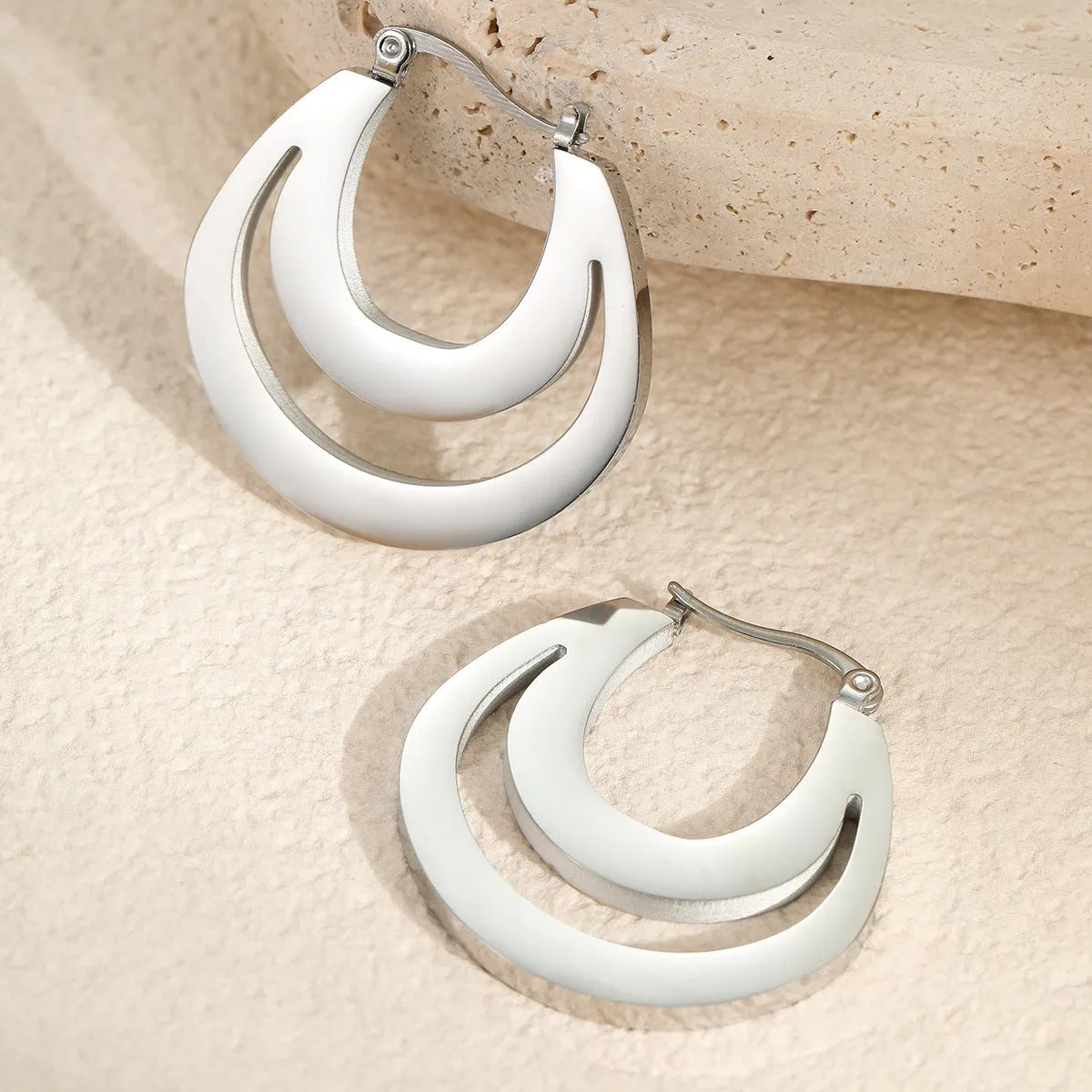 Geometric gold plated hoop earrings with round ring design on stainless steel background