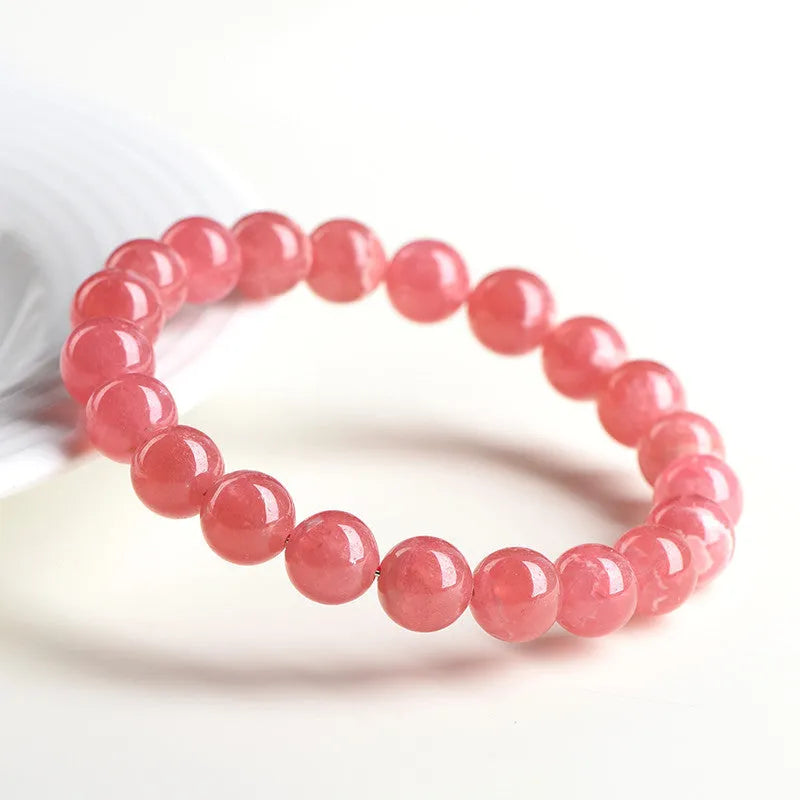 Women's red rhodochrosite crystal bracelet with geometric pattern and longevity lock clasp showing natural stone variations