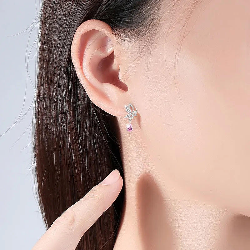 A pair of sterling silver butterfly stud earrings with crystal details on a white background.
