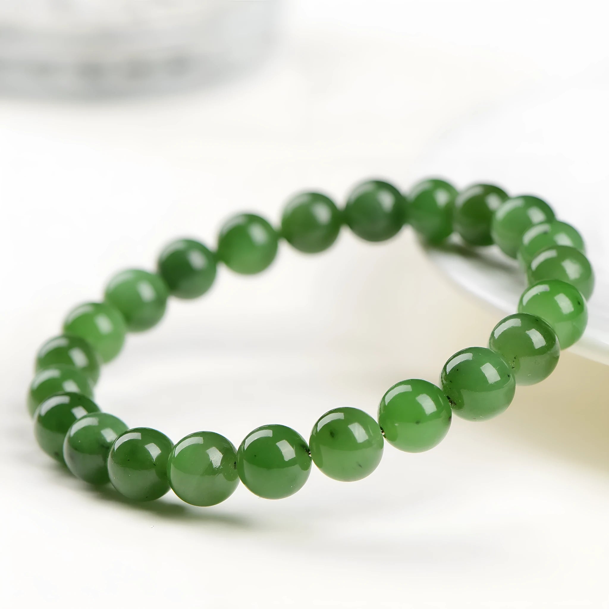 Polished Hetian jade jasper ball bracelet showing natural stone beads in multiple size options on a wrist.