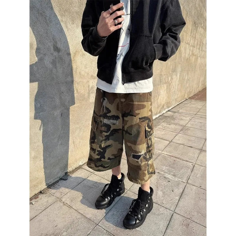 Men's camouflage cropped jeans with patchwork detailing and distressed rips in loose straight-leg fit