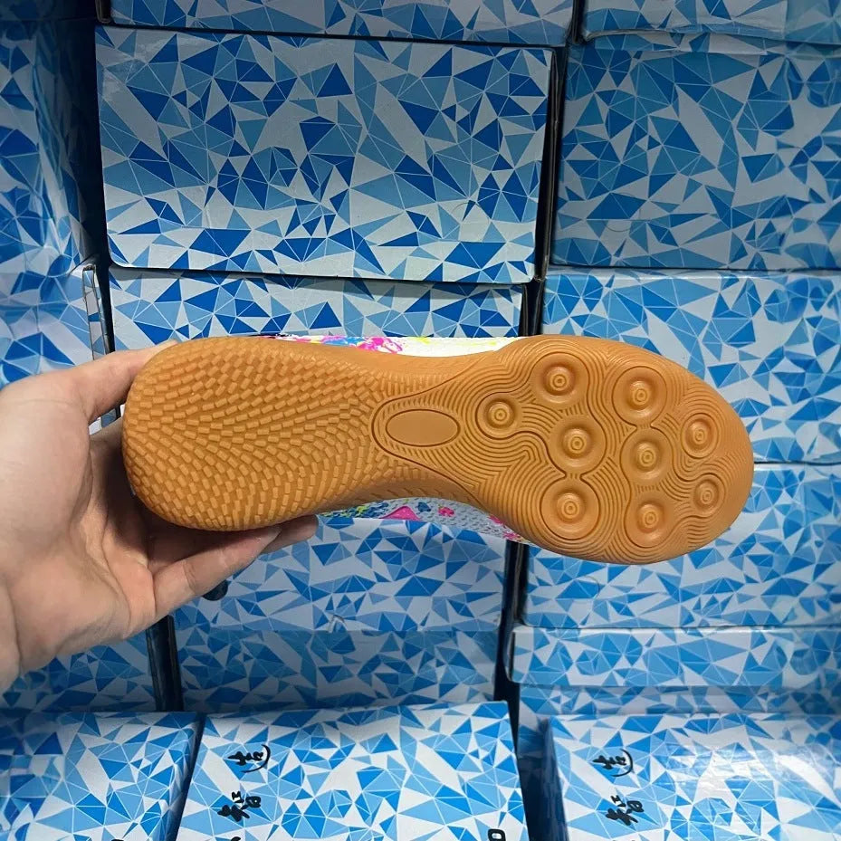 Low-top football shoes with studded rubber outsoles in black and yellow colour combination