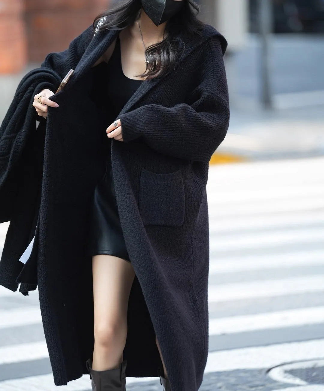 Long grey knitted women's cardigan trench coat with a hood and long sleeves.