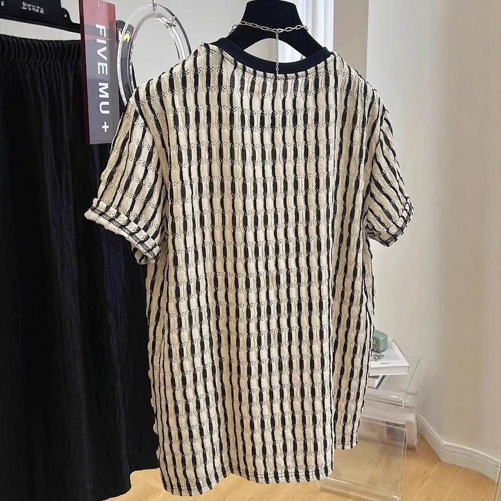Man wearing a black and white striped loose casual short sleeve shirt made from linen and silk blend.
