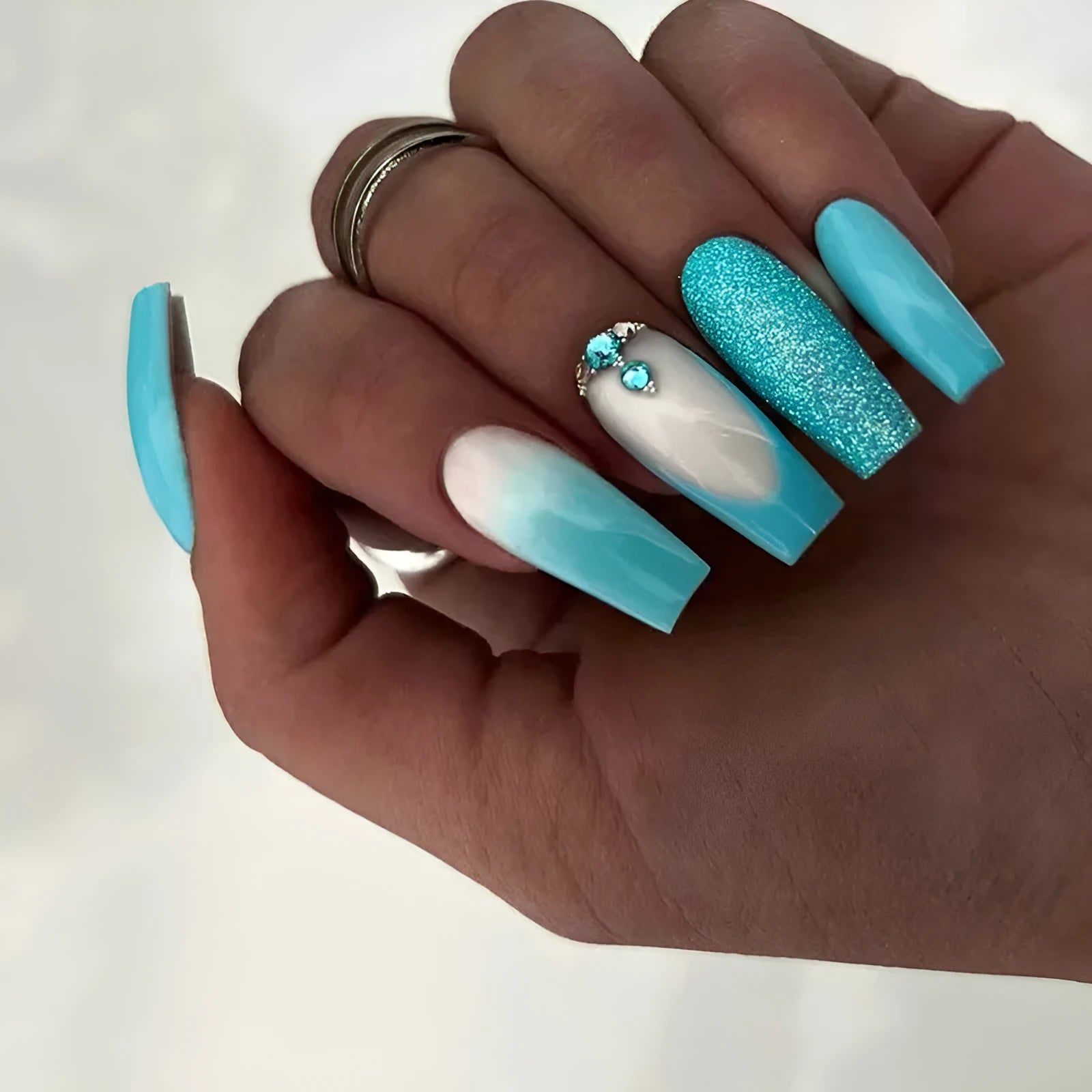 Long ballet shaped false nails in a solid smart blue diamond colour with glue.
