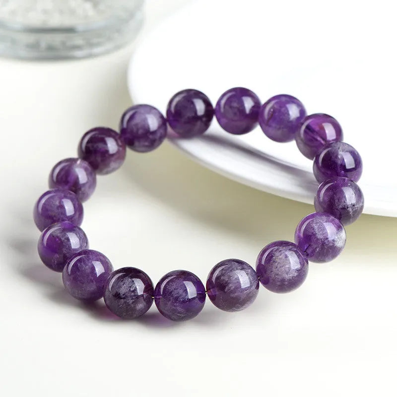 Natural feather amethyst crystal bracelet with geometric shape and silver fastener on wrist.