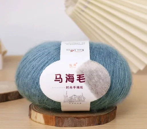 DIY mohair scarf weaving kit showing one wool ball and a selection of 34 colour options including white, pink, blue and green.