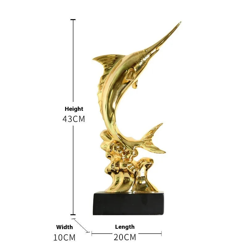 Close-up of a detailed resin European swordfish ornament in bright gold colour on a shelf.