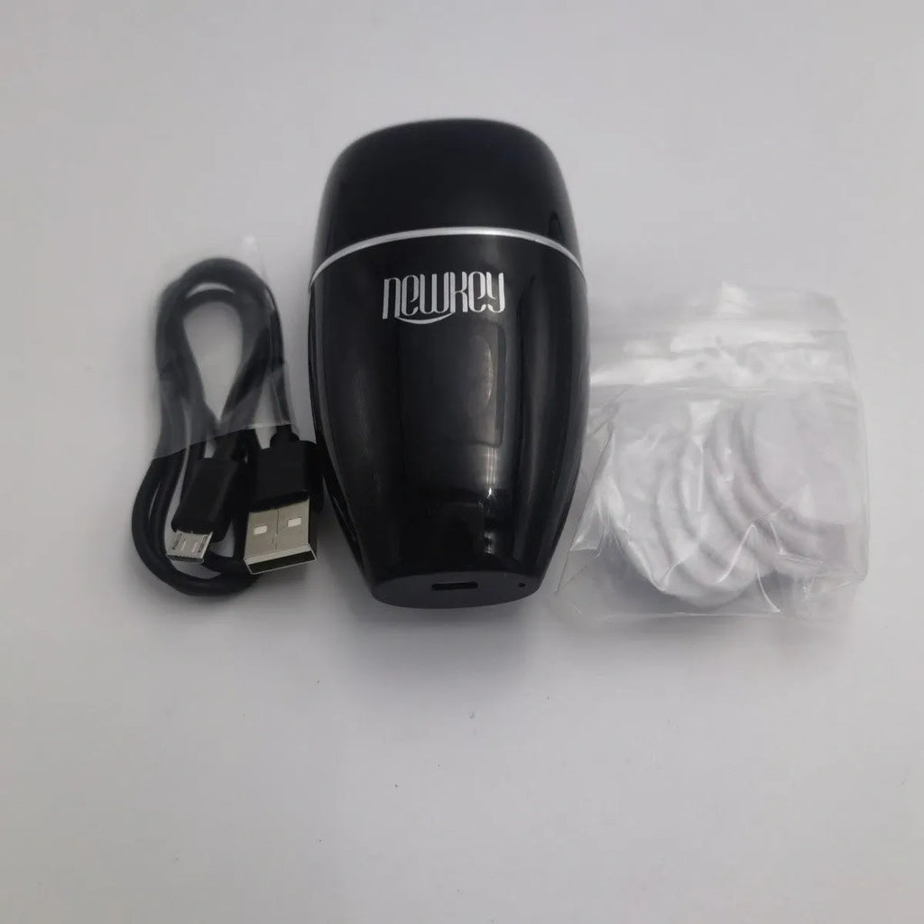 Black electric lip plumper device with a silicone tip next to a white USB charging cable.