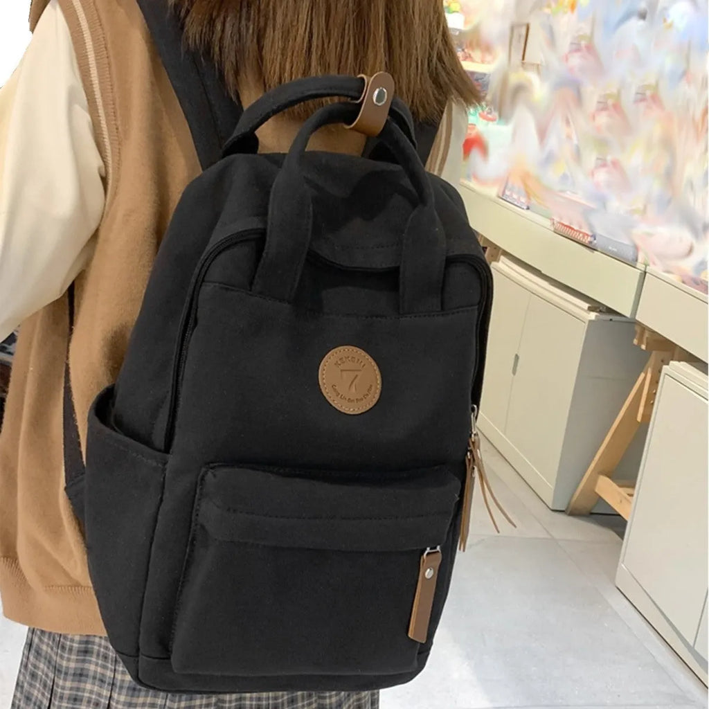 Black Oxford cloth retro-style backpack with curved shoulder straps and sewing thread details
