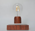 Magnetic levitation floating light bulb hovering above imitation wood base with universal voltage specification