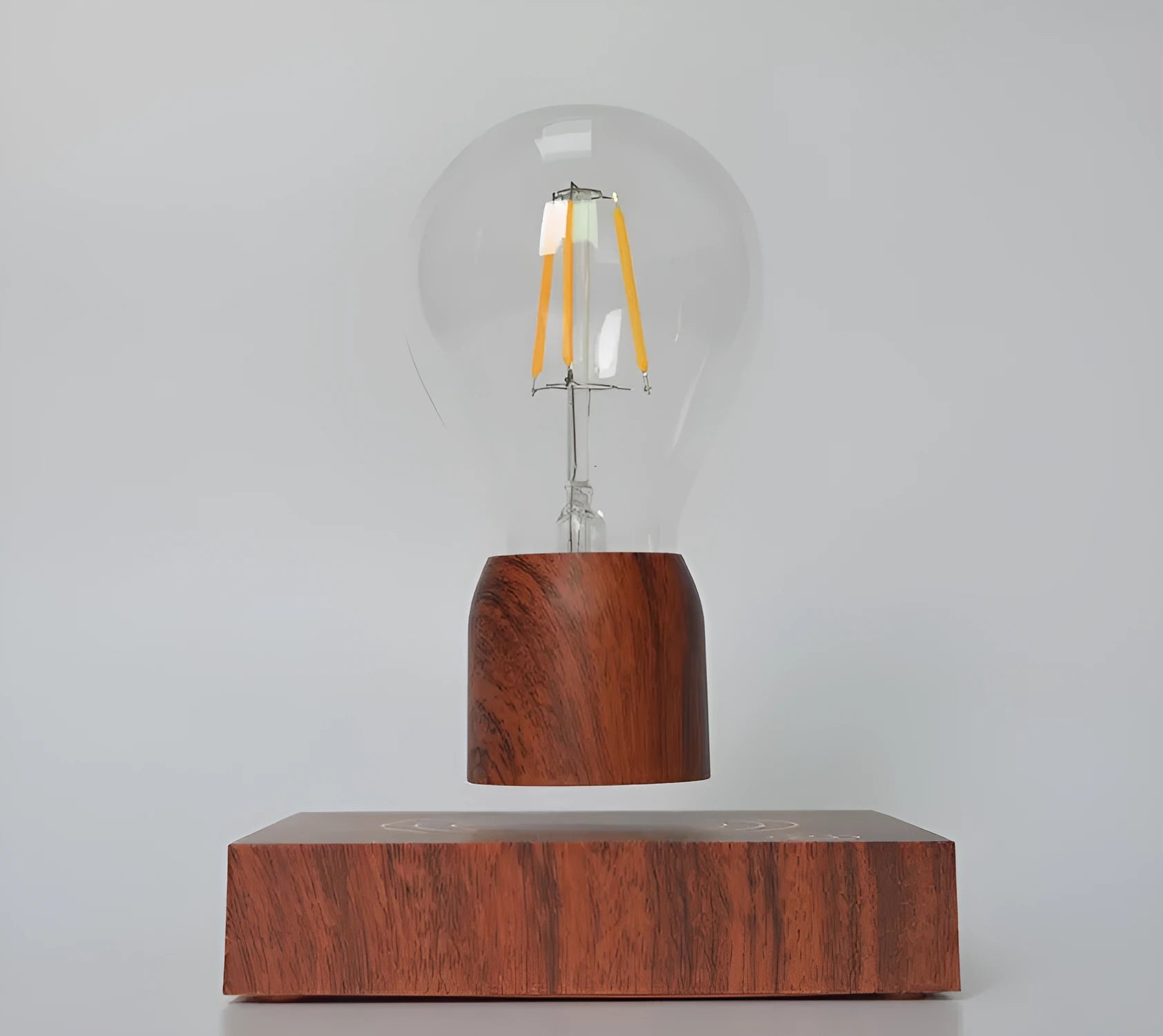 Magnetic levitation floating light bulb hovering above imitation wood base with universal voltage specification