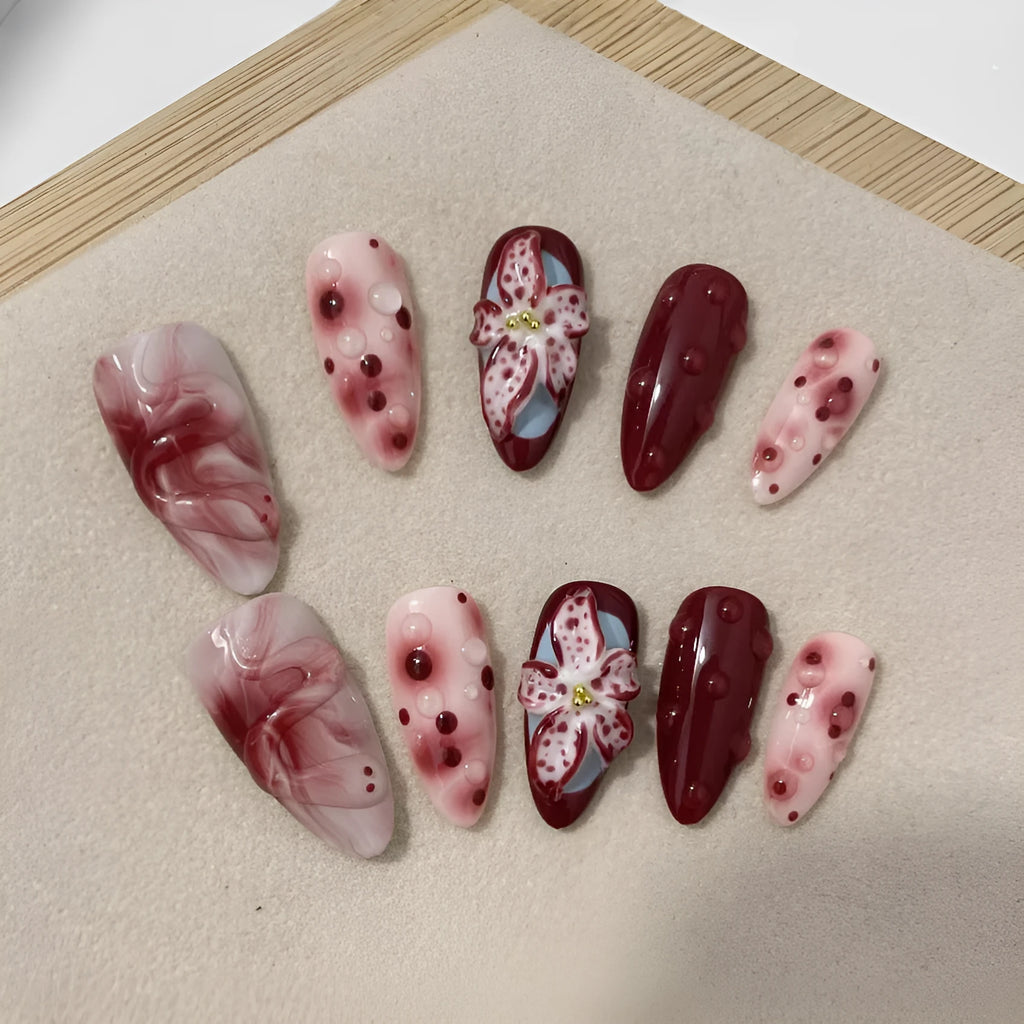 Almond-coloured false nails with hand-painted 3D carved rose designs, shown in medium length.