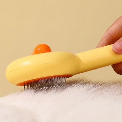 Yellow and white pet grooming comb with duck design and needle teeth for cats and dogs.
