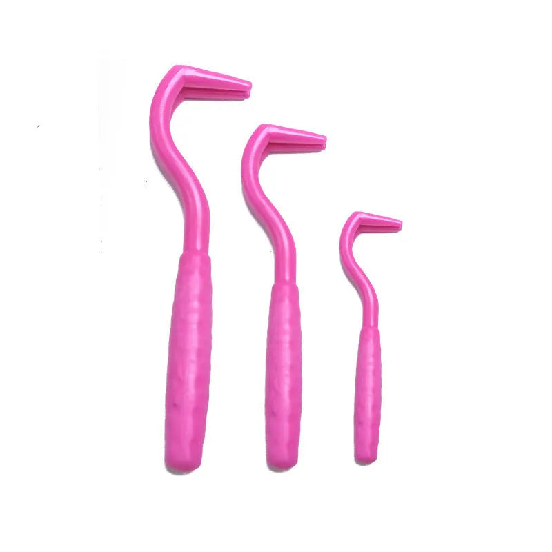 Set of three coloured ABS plastic tick removal hooks for dogs on a white background.