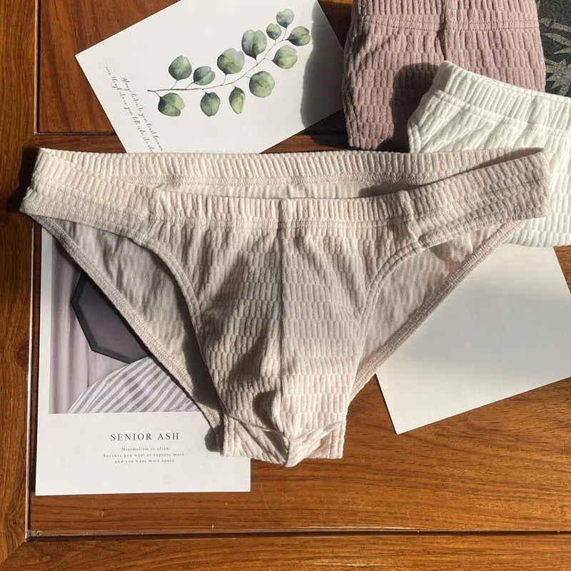 Men's solid colour cotton briefs with mid waist and triangle style in apricot black and skin colour.