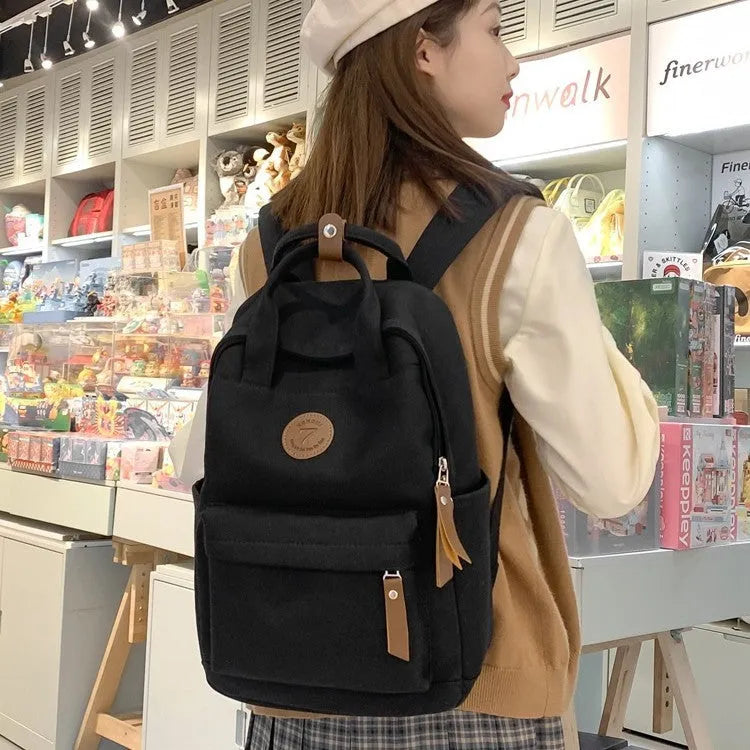 Black Oxford cloth retro-style backpack with curved shoulder straps and sewing thread details
