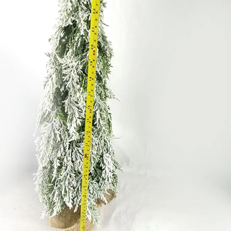 Small 24-inch white artificial Christmas tree with LED lights and snow-covered branches on a desktop.