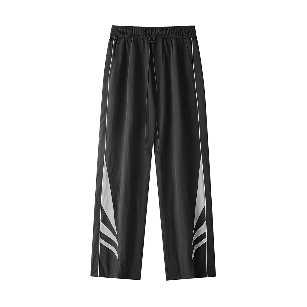 Men's black straight leg loose fit summer sports trousers with an elastic waist on a grey background.