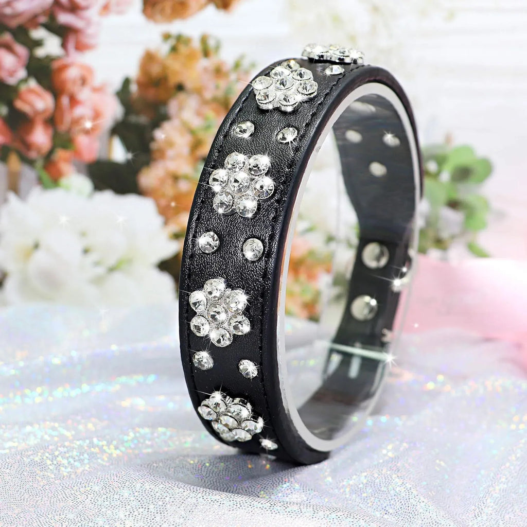 Black PU leather dog collar with rhinestone flowers and metal studs, showing the adjustable eyelets and D-ring.