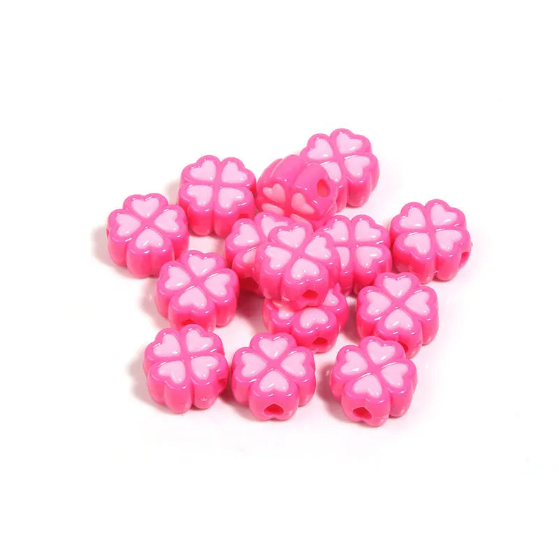 A pile of 15mm frosted acrylic four-leaf clover beads in mixed colours including pink, green, and blue.