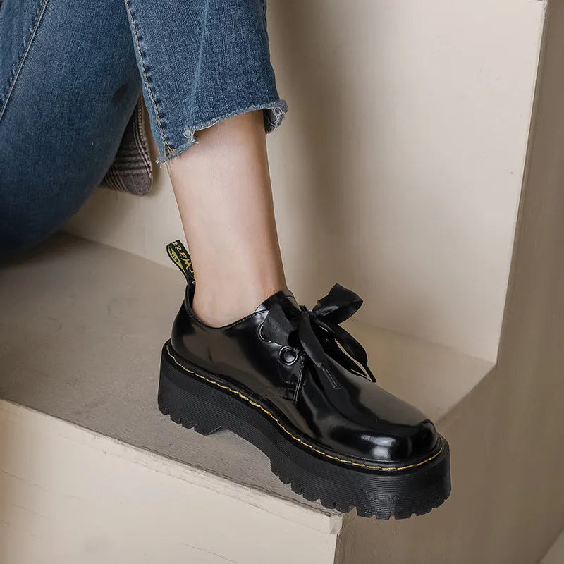 Women's thick soled leather shoes with ribbon cross straps and lace closure in black or white