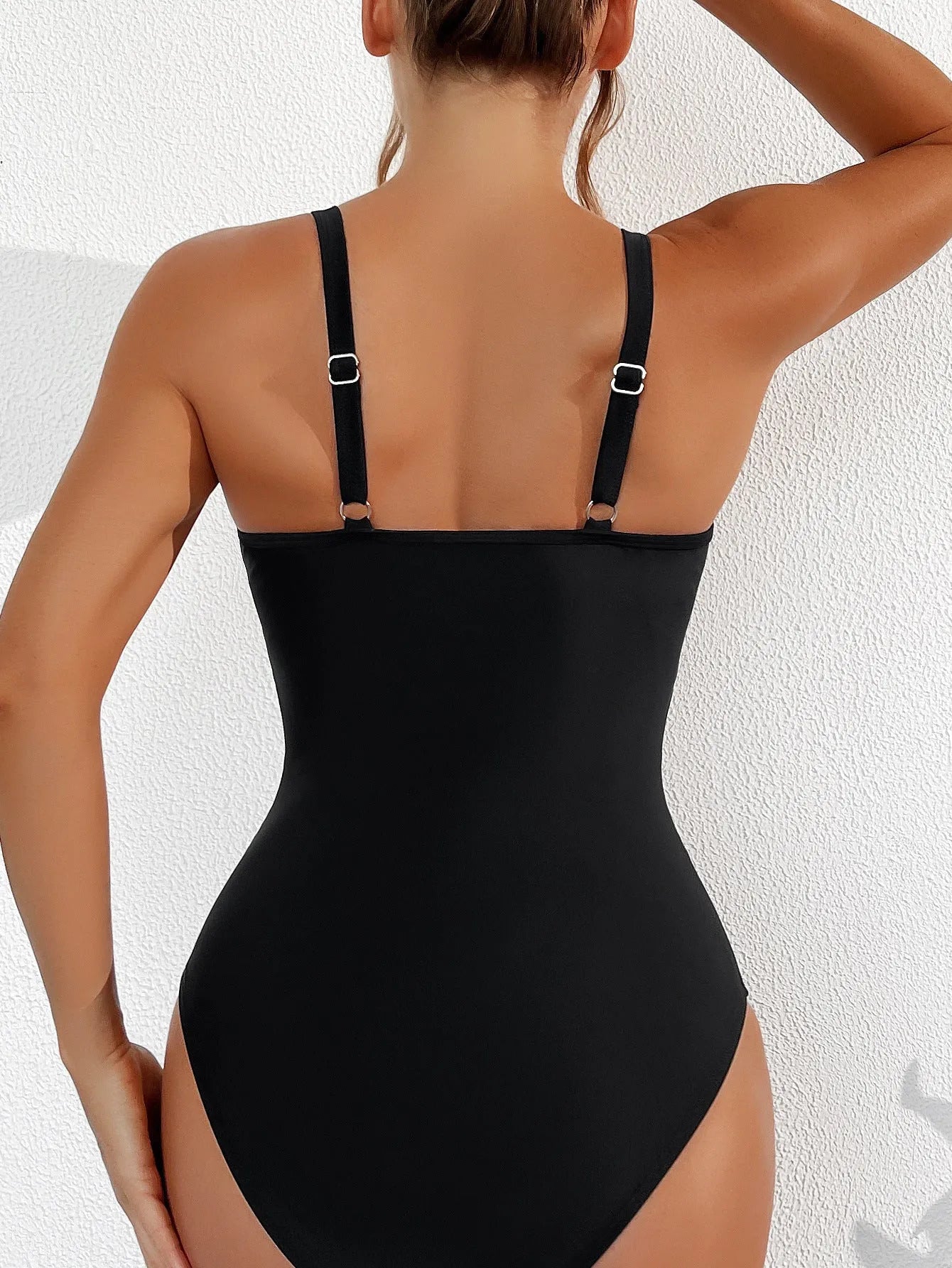Black halter neck one-piece swimsuit with mesh detailing on adult female model