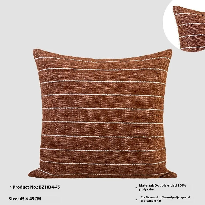 Square Chinese ancient style decorative cushion with a geometric pattern in a brown Maillard colour on a grey sofa.