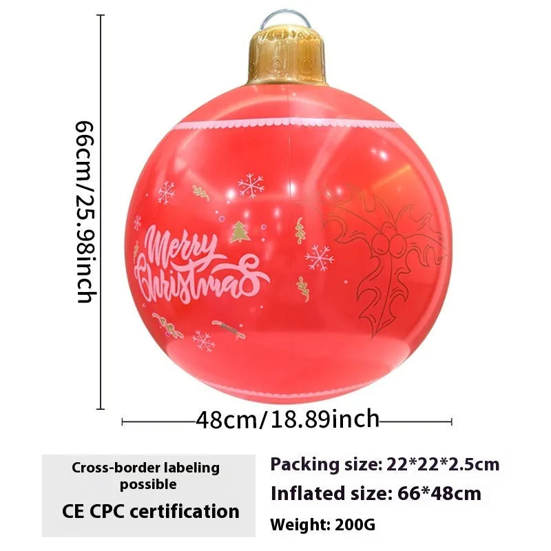 Large red and white inflatable Christmas ball with snowflake design in garden setting
