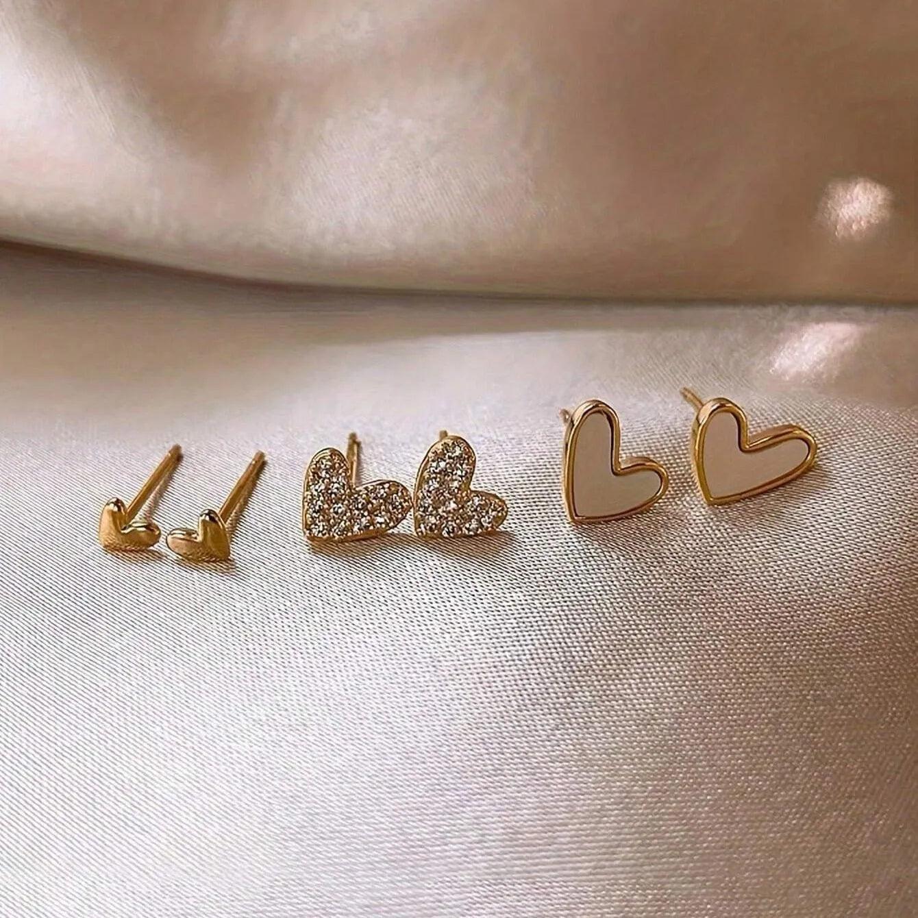 Three pairs of heart-shaped alloy earrings with love motifs in four colour options